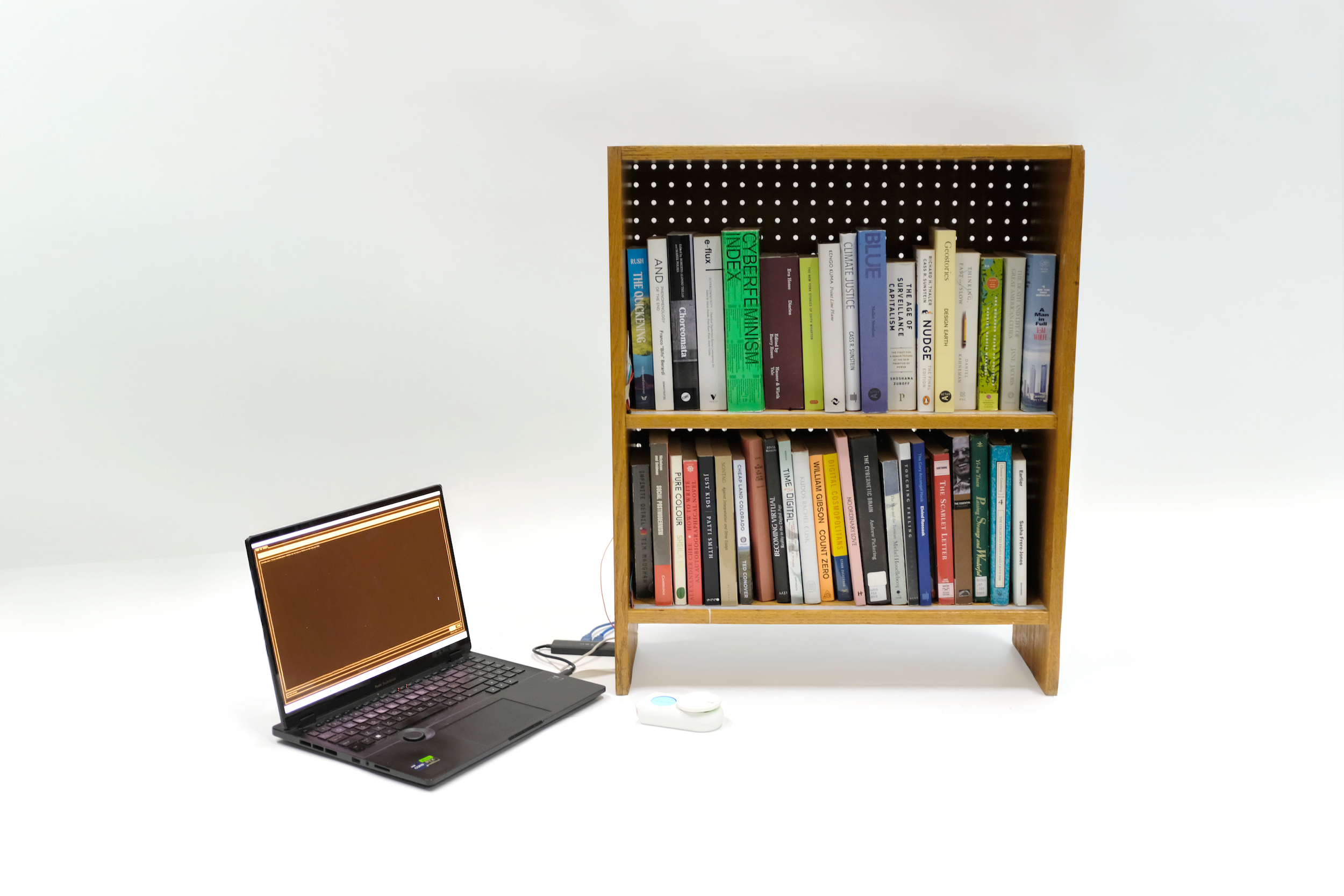 Photo of a bookshelf with a computer linked to it